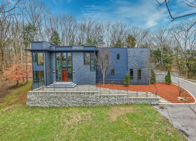 view of front facade with fence, a front lawn, and brick siding