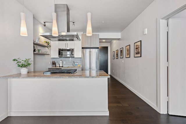 kitchen with island exhaust hood, decorative backsplash, appliances with stainless steel finishes, dark wood-type flooring, and a peninsula