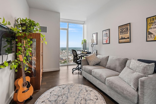 living room featuring a wall of windows, wood finished floors, visible vents, and baseboards