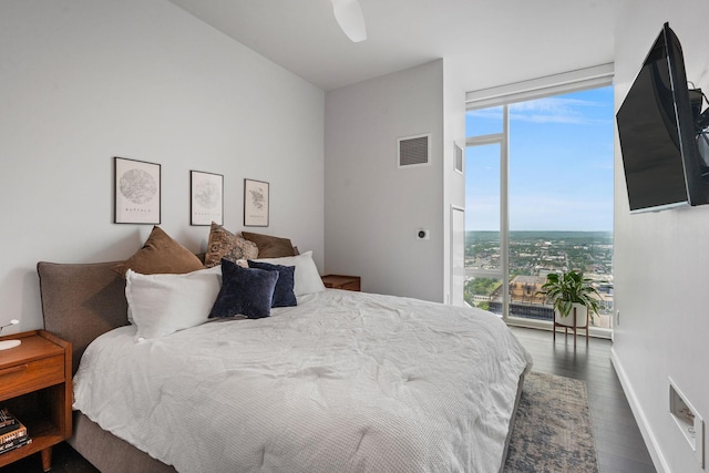 bedroom with a wall of windows, wood finished floors, and visible vents