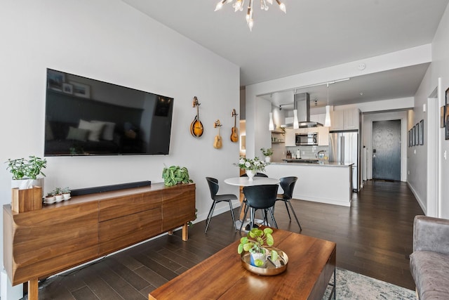 living room featuring baseboards, dark wood finished floors, and a notable chandelier