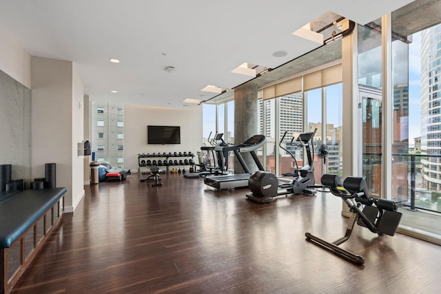 exercise room featuring expansive windows, wood finished floors, and recessed lighting