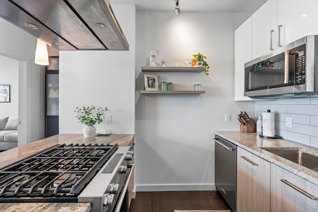 kitchen with dark wood-style floors, decorative backsplash, appliances with stainless steel finishes, white cabinets, and light stone countertops