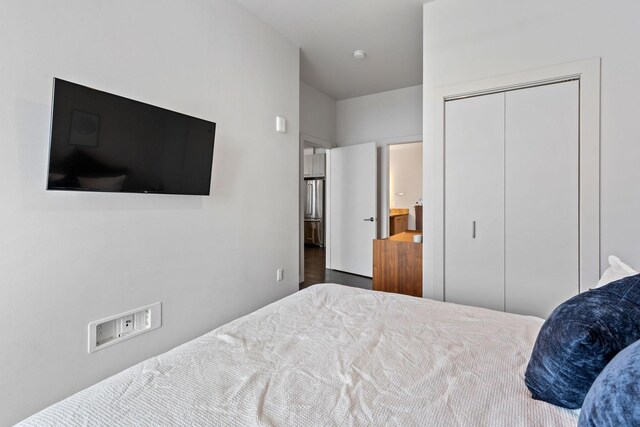 bedroom featuring high end refrigerator and a closet