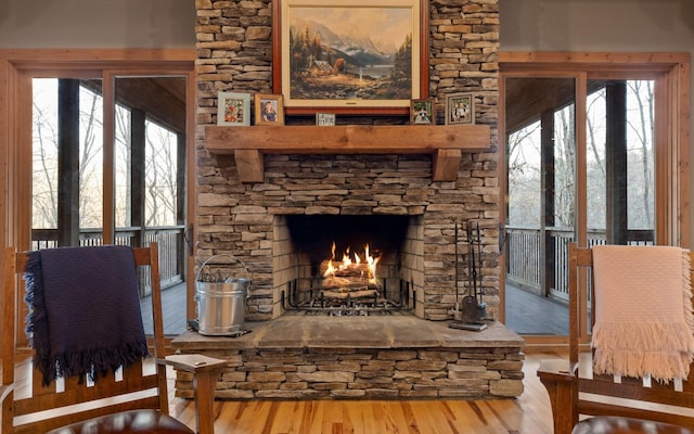 living area featuring a fireplace, plenty of natural light, and wood finished floors