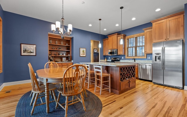 dining space with recessed lighting, visible vents, baseboards, light wood finished floors, and an inviting chandelier