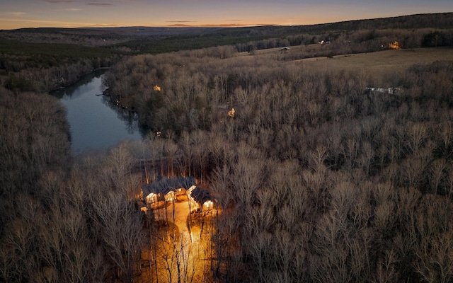 birds eye view of property featuring a water view and a wooded view