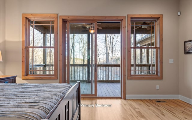 bedroom featuring light wood finished floors, access to exterior, and baseboards