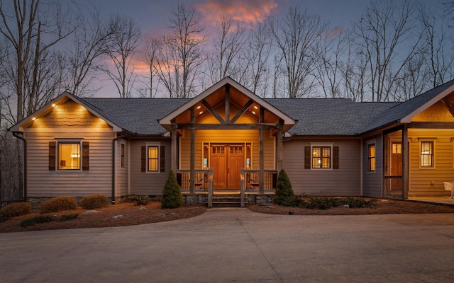 view of front facade with concrete driveway, a porch, crawl space, and a shingled roof