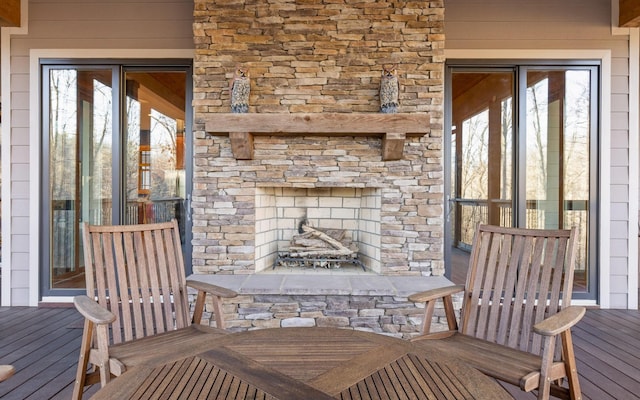 wooden terrace featuring an outdoor stone fireplace