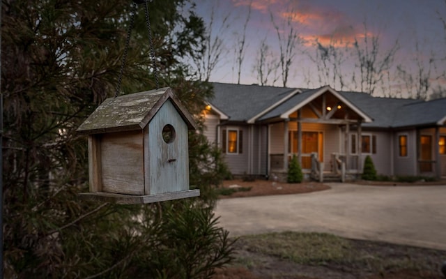 view of front of house with an outbuilding, concrete driveway, and a storage shed