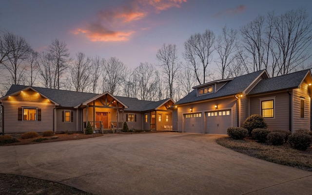 view of front of home featuring a garage, roof with shingles, and driveway