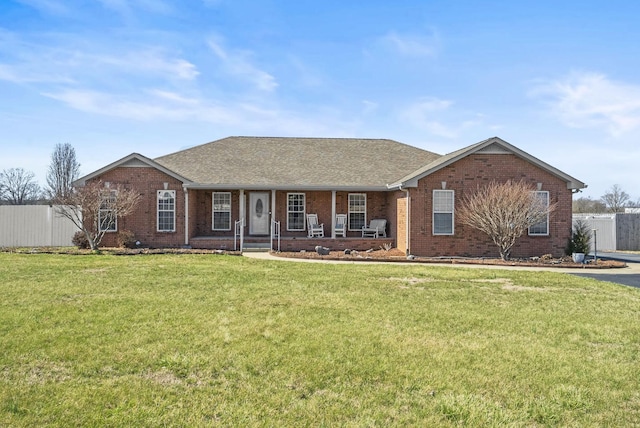 single story home with covered porch, brick siding, fence, and a front lawn