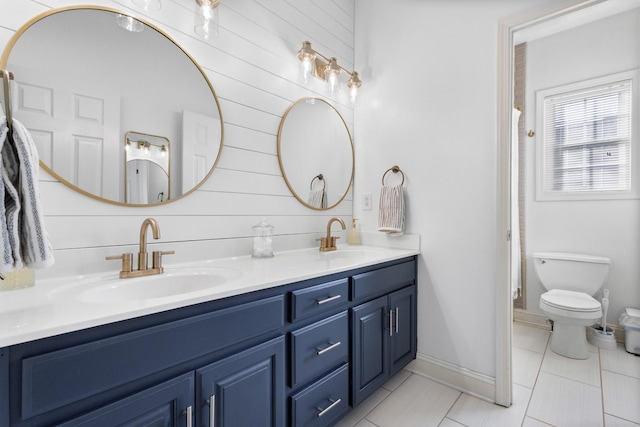 full bath with double vanity, tile patterned flooring, a sink, and toilet