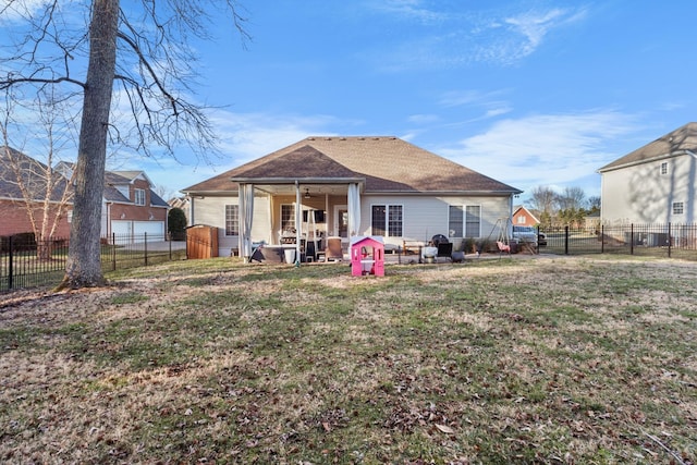 rear view of house featuring a patio, a lawn, a fenced backyard, and roof with shingles