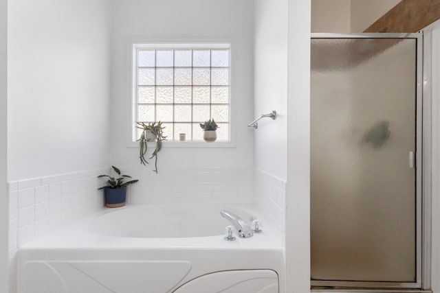 bathroom with a stall shower and a bath