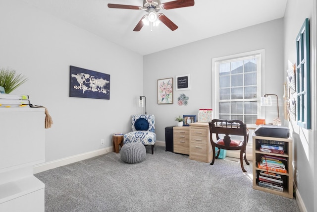 carpeted office featuring baseboards and a ceiling fan