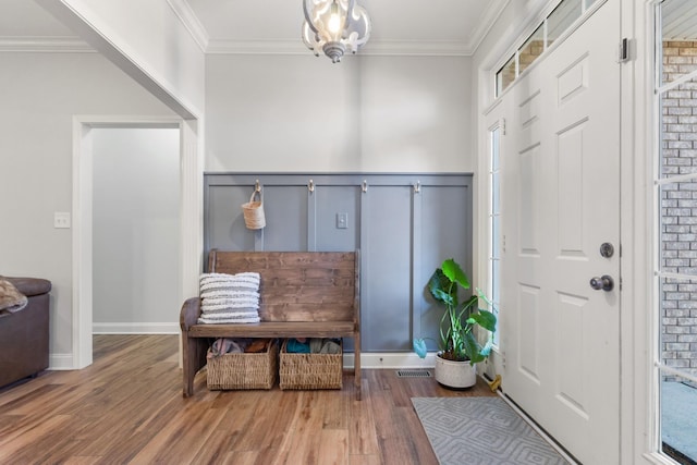 mudroom with wood finished floors, visible vents, and crown molding