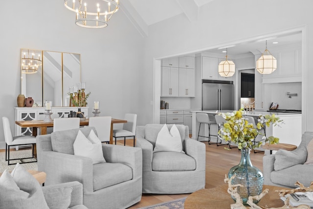 living area with a chandelier, light wood-type flooring, and lofted ceiling with beams