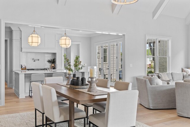 dining room with light wood-type flooring and beam ceiling