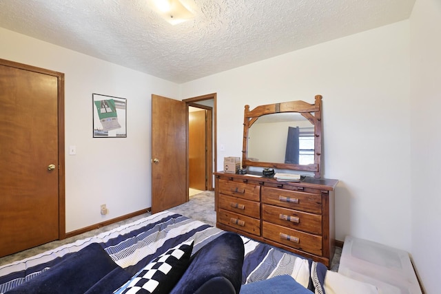 bedroom featuring carpet floors, baseboards, and a textured ceiling