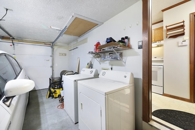 laundry room featuring a garage, laundry area, separate washer and dryer, and a textured ceiling