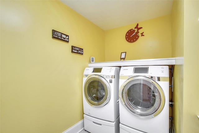 laundry area with laundry area, baseboards, and washing machine and clothes dryer