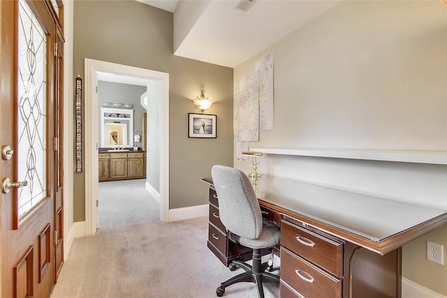 office with light colored carpet, a sink, and baseboards