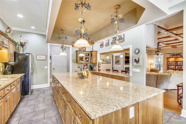 kitchen with light stone counters, decorative light fixtures, crown molding, glass insert cabinets, and a kitchen island