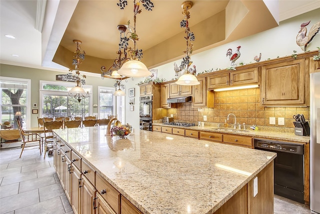 kitchen with tasteful backsplash, a raised ceiling, under cabinet range hood, black appliances, and a sink