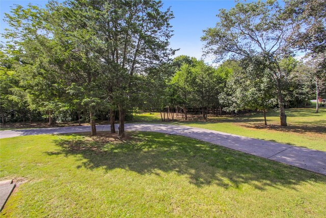 surrounding community with driveway and a lawn