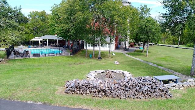 view of yard featuring an outdoor fire pit, a patio area, an outdoor pool, and fence