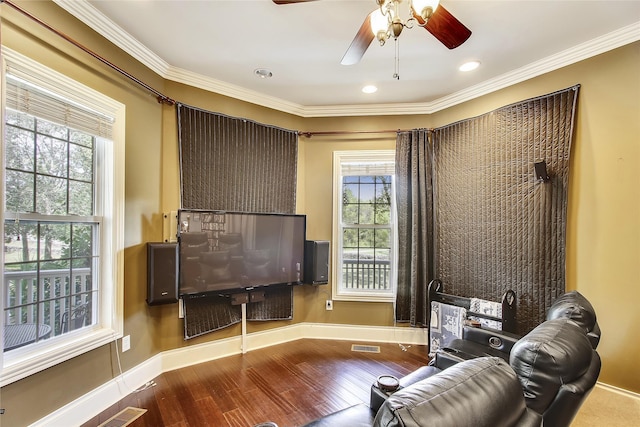 sitting room with crown molding, wood finished floors, visible vents, and baseboards