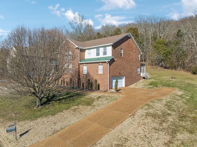 view of home's exterior featuring a garage, metal roof, brick siding, and a lawn