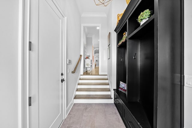 mudroom with crown molding, baseboards, and tile patterned floors