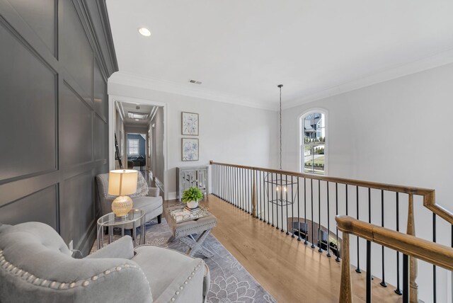 sitting room with recessed lighting, visible vents, crown molding, and wood finished floors