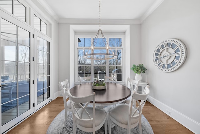 dining area featuring a wealth of natural light, crown molding, and wood finished floors