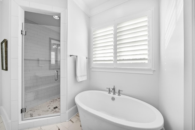 bathroom with marble finish floor, a stall shower, and a freestanding tub