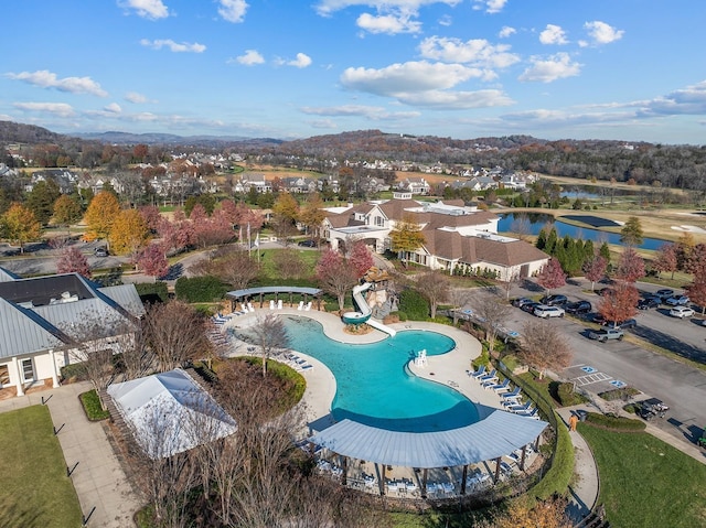 pool featuring a water view, a patio area, and a residential view