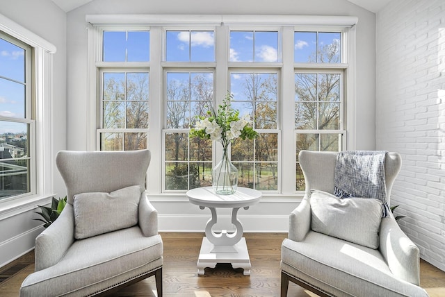 living area with plenty of natural light, visible vents, and vaulted ceiling