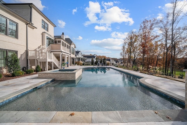 outdoor pool featuring a patio area, a residential view, stairway, and an in ground hot tub