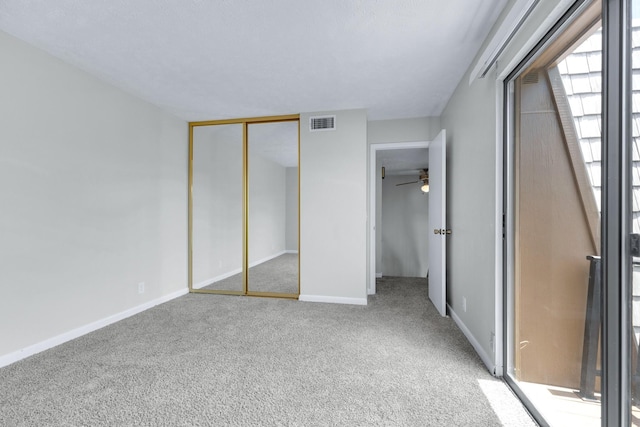 unfurnished bedroom with a closet, carpet flooring, visible vents, and baseboards