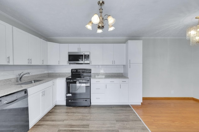 kitchen with stainless steel microwave, a sink, a chandelier, dishwasher, and black / electric stove