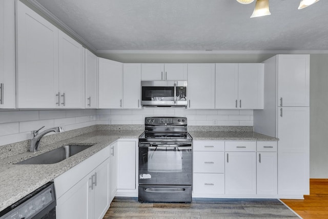 kitchen with dishwashing machine, stainless steel microwave, wood finished floors, black electric range, and a sink