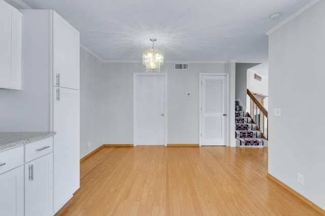 unfurnished dining area with stairway, crown molding, visible vents, and light wood-style floors