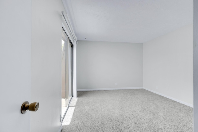 unfurnished room with carpet flooring and baseboards