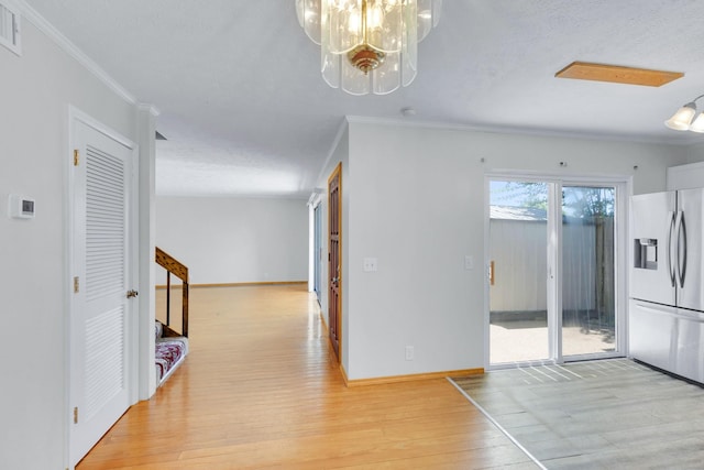 interior space with baseboards, stairway, light wood-style flooring, and crown molding