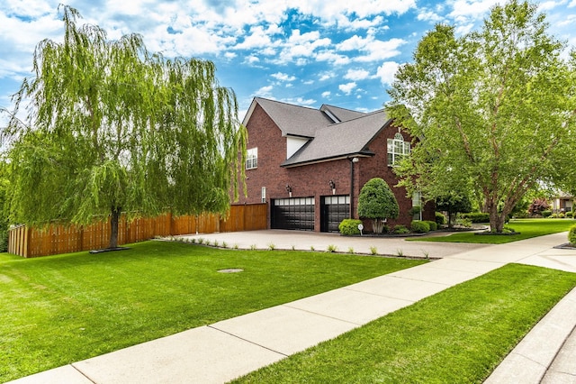 view of side of home featuring concrete driveway, a lawn, an attached garage, fence, and brick siding