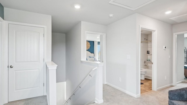 hall featuring attic access, baseboards, light colored carpet, an upstairs landing, and recessed lighting