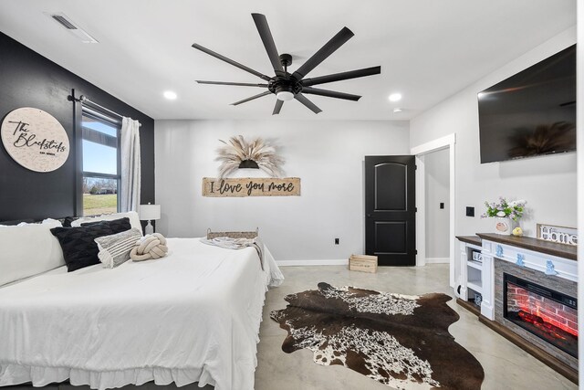 bedroom with concrete flooring, recessed lighting, visible vents, baseboards, and a glass covered fireplace